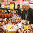 Imagen de un hombre que observa la promoción de productos cárnicos en un supermercado. RAMIRO