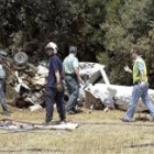 Servicios de la Guardia Civil inspeccionan los restos de la avioneta
