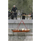 Los bomberos sacan del río el cuerpo del joven.