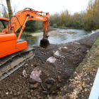 Trabajos de construcción de la escollera que evitará que el Porma lamine la LE-213 en Villarente.