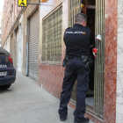 Un agente de la Policía Nacional cerrando el acceso al Bar Cani, en la calle Truchillas, donde se produjo el suceso.