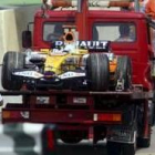 El monoplaza de Alonso, en el momento de ser retirado por las asistencias tras el fallo en el motor