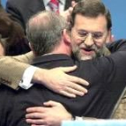 Rajoy y Rato se abrazan en el acto celebrado ayer