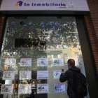 Un joven toma nota de una de las ofertas de pisos disponibles en alquiler en una agencia de Barcelona, esta semana.