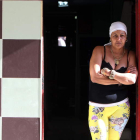 Una mujer permanece en la puerta de su casa en La Habana junto a una imagen del Che Guevara
