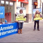 Un grupo de activistas de Amnistía Internacional posan con los carteles de denuncia