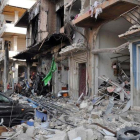 Coches y edificios destruidos cerca del lugar de un doble atentado con bomba en Homs, el 21 de febrero.