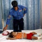 Un policía iraquí observa a un bebé herido en uno de los atentados perpetrados ayer en Bagdad