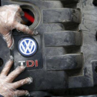 Un operario coloca la tapa de un motor diésel VW .