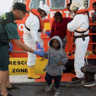 Un guardia civil ayuda a un niño que llegó en una patera a las costas españolas. MIOGUEL PAQUET