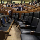 La bancada azul del Gobierno permanece vacía mientras la oposición pide explicaciones al también ausente Luis de Guindos, en el pleno del Congreso.
