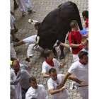 Los mozos corren ante los Victoriano del Río Cortés, en el tercer encierro de los sanfermines.