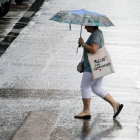 na persona se resguardan con el paraguas en plena tormenta a primeras horas de hoy en Valencia.