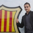 Afellay posa ante el escudo del club azulgrana.
