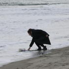 Mark Kanekita, de 37 años, lanza flores al mar en memoria de las víctimas del terremoto y posterior tsunami de hace cinco años en el distrito de Abraham en Sendai (Japón).