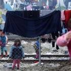 Niños refugiados juegan entre ropas colgadas para secar entre alambradas en un campo de refugiados de Idomeni (Grecia), junto a la frontera con Macedonia, este miércoles.