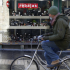 Un hombre pasa frente a un escaparate comercial de León. FERNANDO OTERO