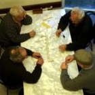 Unos ancianos practican su juego favorito de mesa, el dominó