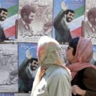 Mujeres iraníes pasan delante de unos carteles electorales