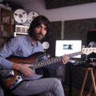 El activo músico y realizador leonés Juan Marigorta, tocando la guitarra en su estudio.