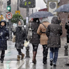Varias personas pasean por una céntrica calle de Granada a pesar de la nieve que ha caído en las últimas horas en la ciudad, donde se ha declarado la alerta amarilla debido a las consecuencia del temporal de viento, frío y nieve que afecta a casi todo el