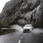 Un coche circula entre la lluvia en Vegacervera
