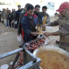 Egipcios hacen cola para recibir comida en el paso fronterizo de Ras el Jedir (Túnez).