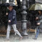 Dos personas se protegen de la lluvia con un paraguas. JESÚS DIGES