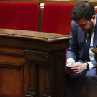 Pere Aragonés consulta su teléfono móvil ayer, en el Pleno del Parlament. QUIQUE GARCÍA