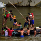 Inmigrantes hondureños socorren a un hombre y un niño en el río Suchiate, en el puente fronterizo de Ciudad Hidalgo, entre Guatemala y México, el 20 de octubre del 2018.