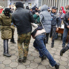 Prorrusos detienen a un hombre armado durante una protesta en el este de Ucrania.