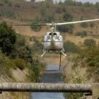 Un helicóptero se dispone a cargar agua para combatir un frente de fuego