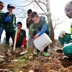 Un grupo de niños realizan la plantación de uno de los ejemplares facilitados por Tudela Veguín. RAMIRO