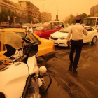 Un policía iraquí organiza el tráfico en Bagdad en medio de una tormenta de arena.