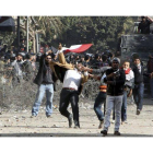 Varios manifestantes egipcios lanzan objetos a las fuerzas de seguridad cerca del Ministerio del Interior en El Cairo, Egipto, hoy, domingo 5 de febrero de 2012.