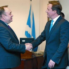 El ministro principal de Escocia, Alex Salmond (izquierda) estrecha la mano del 'premier' británico, David Cameron, ayer en Edimburgo.