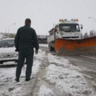 Una quitanieves trabaja en limpiar los accesos de la autopista, un vehículo espera a poder continuar