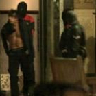 Los agentes de la Ertzaintza salen con uno de los detenidos en un piso de Barakaldo