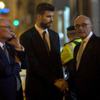 Gerard Piqué (c) saluda al presidente del Banco de Sabadell, Josep Oliu (d), en presencia del CEO y consejero delegado del GSMA, John Hoffman (i) tras la cena de bienvenida al Mobile World Congress (MWC).