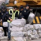 Agentes de la Policía Nacional apilan fardos de droga descargada en la capital grancanaria