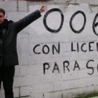 El escritor de ascendencia leonesa Diego Medrano, ante una pintada que refleja su modo de pensar