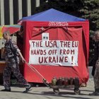 Activistas prorrusos pasan delante de una pancarta contra EE UU y la UE en Ucrania.