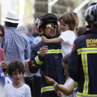 Un bombero con un niño en brazos durante la marcha