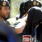 Agentes de la Guardia Civil trasladan a uno de los detenidos durante la redada.
