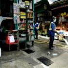 Una de los 10.000 voluntarios limpia con una manguera las calles de Hong Kong