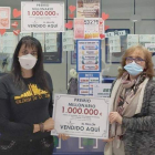 La lotera, Nuria Pérez, sujeta el cartel con el premio de un millón de euros. DL