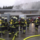 Un grupo de bomberos, mientras intentaba apagar las llamas del taller.