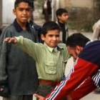 Un niño es cacheado a la entrada de una mezquita en Bagdad para comprobar que no lleva explosivos