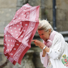 Una mujer se protege contra el viento con su paraguas. LAVANDEIRA JR