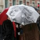 Dos mujeres se guarecen de la lluvia con un paraguas en la calle Ancha de León